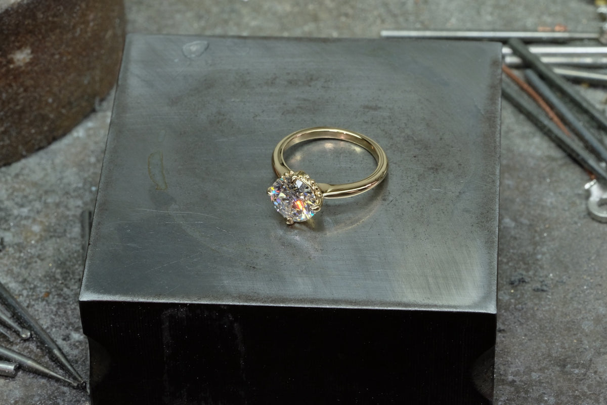 Round diamond solitaire in 18k yellow gold with beaded detailing