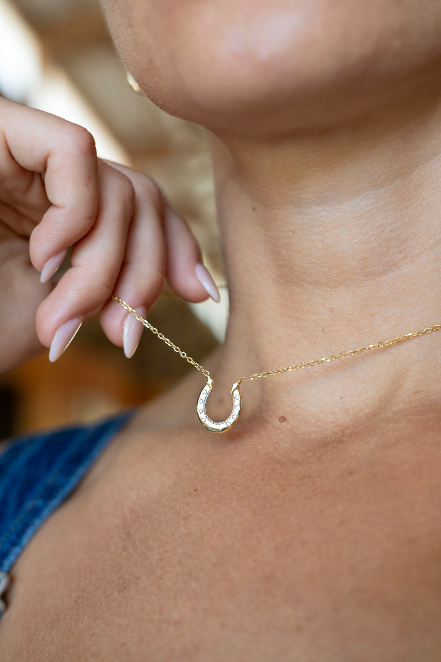 Diamond hoof-shaped pendant worn against skin and denim