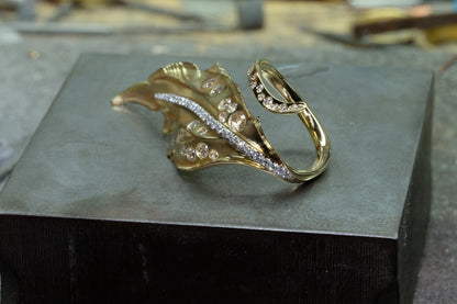 Feather-inspired 18k yellow gold ring with diamonds, band and feather detail