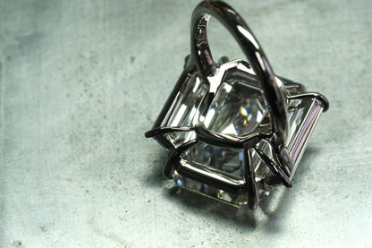 Platinum emerald-cut diamond ring with tapered baguette side stones, open gallery detail